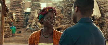 Movie still from “Queen of Katwe” (2016), directed by Mira Nair – A woman wearing a head scarf talking to a man; Close Up shot, Over the shoulder angle