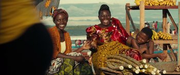 Movie still from “Queen of Katwe” (2016), directed by Mira Nair – Two women sitting next to each other on a bench; Medium shot, Over the shoulder angle