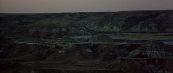 Movie still from “Quest for Fire” (1981), directed by Jean-Jacques Annaud – A view of a mountain range at night time; Extreme Wide shot, High angle