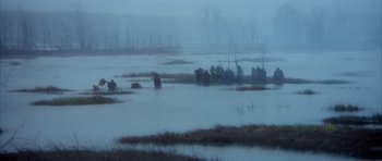Movie still from “Quest for Fire” (1981), directed by Jean-Jacques Annaud – A herd of elephants walking across a flooded field; Extreme Wide shot, High angle