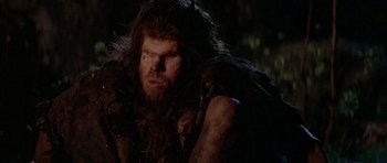 Movie still from “Quest for Fire” (1981), directed by Jean-Jacques Annaud – A person with a beard; Close Up shot, Low angle