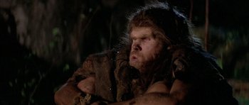 Movie still from “Quest for Fire” (1981), directed by Jean-Jacques Annaud – A person with a beard; Close Up shot, Low angle
