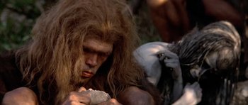 Movie still from “Quest for Fire” (1981), directed by Jean-Jacques Annaud – A person holding a rock; Close Up shot, Low angle