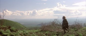 Movie still from “Quest for Fire” (1981), directed by Jean-Jacques Annaud – A view of a valley from the top of a hill; Extreme Wide shot, Low angle