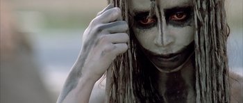 Movie still from “Quest for Fire” (1981), directed by Jean-Jacques Annaud – A person with long white hair; Extreme Close Up shot, Low angle