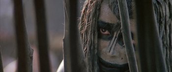 Movie still from “Quest for Fire” (1981), directed by Jean-Jacques Annaud – A person with a face paint; Extreme Close Up shot, Low angle
