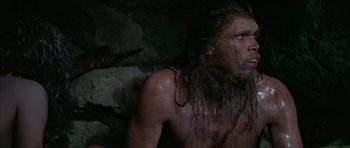 Movie still from “Quest for Fire” (1981), directed by Jean-Jacques Annaud – A person with long hair and a beard; Close Up shot, Low angle