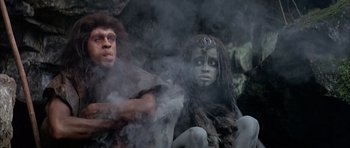 Movie still from “Quest for Fire” (1981), directed by Jean-Jacques Annaud – A man and a woman dressed as cavemen; Medium shot, Low angle