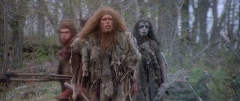 Movie still from “Quest for Fire” (1981), directed by Jean-Jacques Annaud – A group of people dressed in animal skins and fur; Medium shot, Low angle
