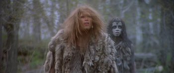 Movie still from “Quest for Fire” (1981), directed by Jean-Jacques Annaud – Two people dressed in furry clothing in the woods; Medium shot, Low angle