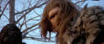 Movie still from “Quest for Fire” (1981), directed by Jean-Jacques Annaud – The face of a person with long hair; Close Up shot, Low angle