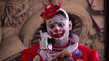 Movie still from “Quick Change” (1990), directed by Howard Franklin – A man in clown makeup talking on a phone; Close Up shot, Low angle