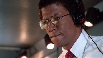 Movie still from “Quick Change” (1990), directed by Howard Franklin – A man wearing glasses and a red neck tie; Close Up shot, Low angle
