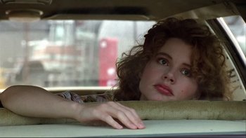 Movie still from “Quick Change” (1990), directed by Howard Franklin – A woman sitting in the back seat of a car; Close Up shot, Over the shoulder angle