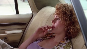 Movie still from “Quick Change” (1990), directed by Howard Franklin – A woman sitting in the back seat of a car; Close Up shot, Low angle