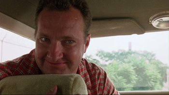 Movie still from “Quick Change” (1990), directed by Howard Franklin – A person sitting in a car; Close Up shot, Low angle