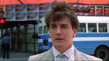 Movie still from “Quick Change” (1990), directed by Howard Franklin – A man with a messy hair style in front of a police car; Close Up shot, Low angle