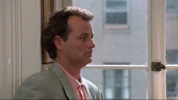 Movie still from “Quick Change” (1990), directed by Howard Franklin – A man in a suit looking out of a window; Close Up shot, Low angle