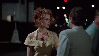 Movie still from “Quick Change” (1990), directed by Howard Franklin – A woman in a yellow dress talking to a man in a suit; Close Up shot, Over the shoulder angle