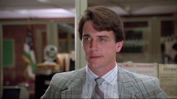 Movie still from “Quick Change” (1990), directed by Howard Franklin – A man in a suit and tie in an office setting; Close Up shot, Low angle