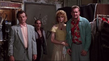 Movie still from “Quick Change” (1990), directed by Howard Franklin – A group of people standing next to each other in a room; Medium shot, Low angle