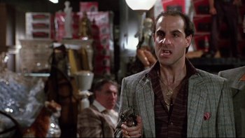 Movie still from “Quick Change” (1990), directed by Howard Franklin – A man holding a gun while standing next to another man; Medium shot, Low angle