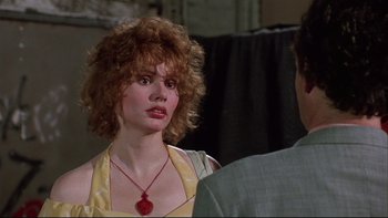 Movie still from “Quick Change” (1990), directed by Howard Franklin – A woman in a yellow dress is talking to a man in a gray suit; Close Up shot, Over the shoulder angle