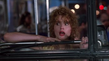 Movie still from “Quick Change” (1990), directed by Howard Franklin – A person with curly hair on a bus; Close Up shot, Low angle