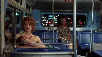 Movie still from “Quick Change” (1990), directed by Howard Franklin – A woman sitting on a bus next to a man; Medium shot, Low angle