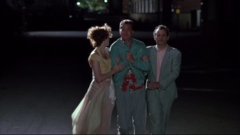 Movie still from “Quick Change” (1990), directed by Howard Franklin – A man and two women standing next to each other in front of a building at night; Medium shot, Low angle