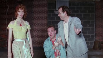 Movie still from “Quick Change” (1990), directed by Howard Franklin – Two men and a woman are standing in front of a brick building; Medium shot, Low angle
