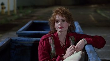Movie still from “Quick Change” (1990), directed by Howard Franklin – A woman in a red shirt sitting on the ground; Close Up shot, Low angle