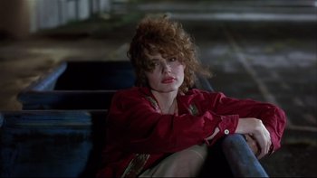 Movie still from “Quick Change” (1990), directed by Howard Franklin – A woman sitting on top of a wooden bench; Close Up shot, Low angle