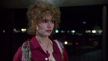Movie still from “Quick Change” (1990), directed by Howard Franklin – A woman with curly hair wearing a red shirt; Close Up shot, Over the shoulder angle