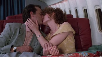 Movie still from “Quick Change” (1990), directed by Howard Franklin – A man and a woman kissing on a plane seat; Close Up shot, Low angle