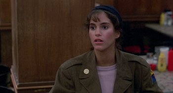 Movie still from “Quicksilver” (1986), directed by Thomas Michael Donnelly – A young woman wearing a hat and a jacket; Close Up shot, Over the shoulder angle