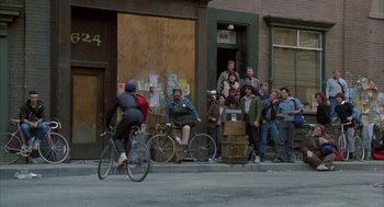 Movie still from “Quicksilver” (1986), directed by Thomas Michael Donnelly – A group of people standing on the side of the street; Wide shot, Over the shoulder angle