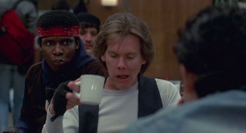 Movie still from “Quicksilver” (1986), directed by Thomas Michael Donnelly – A man holding a coffee cup in his hand; Close Up shot, Over the shoulder angle