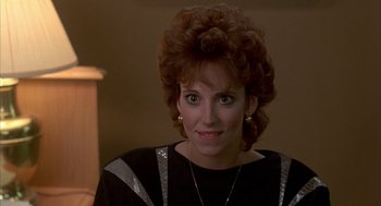 Movie still from “Quicksilver” (1986), directed by Thomas Michael Donnelly – A person wearing a black and white shirt; Close Up shot, Over the shoulder angle