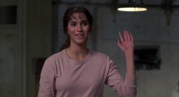 Movie still from “Quicksilver” (1986), directed by Thomas Michael Donnelly – A woman waving at the camera with her hand in the air; Close Up shot, Over the shoulder angle