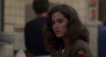 Movie still from “Quicksilver” (1986), directed by Thomas Michael Donnelly – A young woman in a military uniform looks at the camera; Close Up shot, Over the shoulder angle