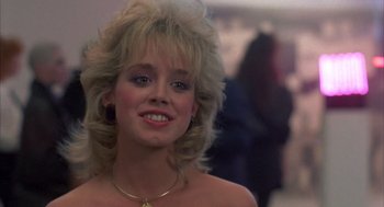 Movie still from “Quicksilver” (1986), directed by Thomas Michael Donnelly – A person wearing a necklace; Close Up shot, Over the shoulder angle