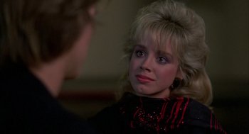 Movie still from “Quicksilver” (1986), directed by Thomas Michael Donnelly – A young woman is looking at a man; Close Up shot, Over the shoulder angle