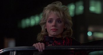 Movie still from “Quicksilver” (1986), directed by Thomas Michael Donnelly – A woman with blonde hair and a red bow tie; Close Up shot, Low angle
