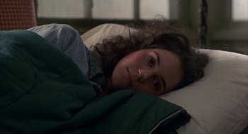 Movie still from “Quicksilver” (1986), directed by Thomas Michael Donnelly – A woman laying in a bed with her head on a pillow; Close Up shot, High angle