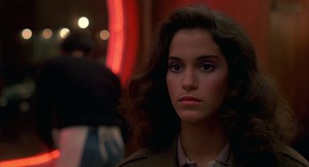 Movie still from “Quicksilver” (1986), directed by Thomas Michael Donnelly – A young woman is looking into the camera; Close Up shot, Over the shoulder angle