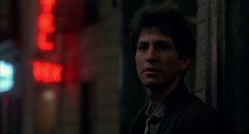 Movie still from “Quicksilver” (1986), directed by Thomas Michael Donnelly – A person wearing a suit and tie; Close Up shot, Low angle