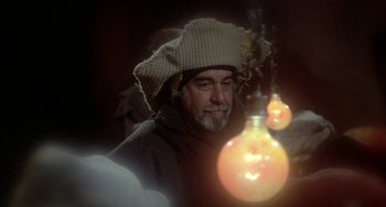 Movie still from “Quintet” (1979), directed by Robert Altman – An old man wearing a hat sitting in front of a lamp; Close Up shot, Over the shoulder angle