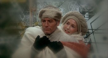 Movie still from “Quintet” (1979), directed by Robert Altman – A man and a woman dressed in winter clothing; Medium shot, Low angle