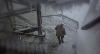 Movie still from “Quintet” (1979), directed by Robert Altman – A man walking up a snow covered staircase; Wide shot, Overhead angle